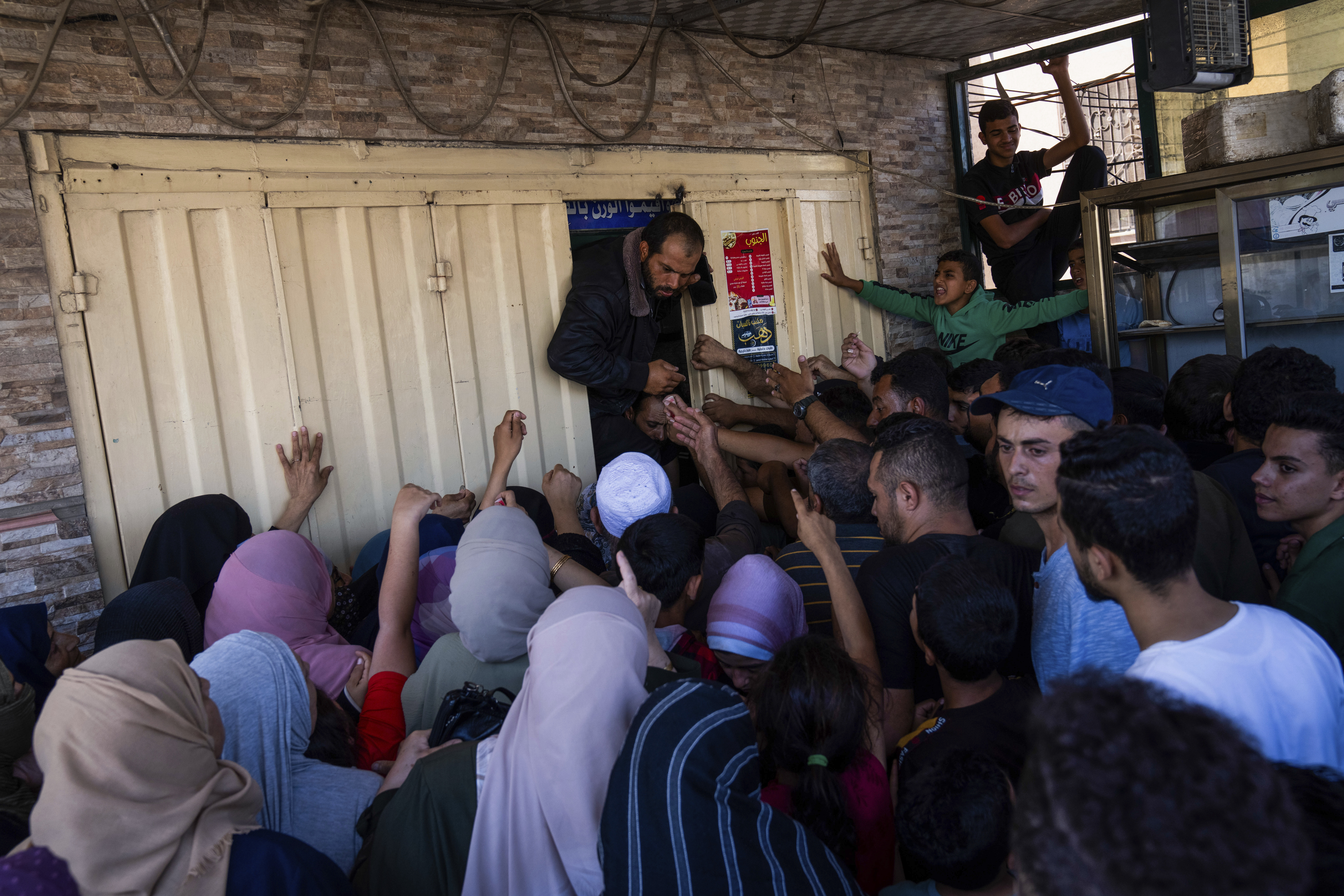 Palestinians crowding to buy bread from a bakery, in Khan Younis, Gaza Strip, Sunday, Oct, 15, 2023. Israel has cut off the flow of food to Gaza after a Hamas attack last week killed 1,300 people and Israel's retaliatory strikes killed more than 2,300 Palestinians. AP Photo
